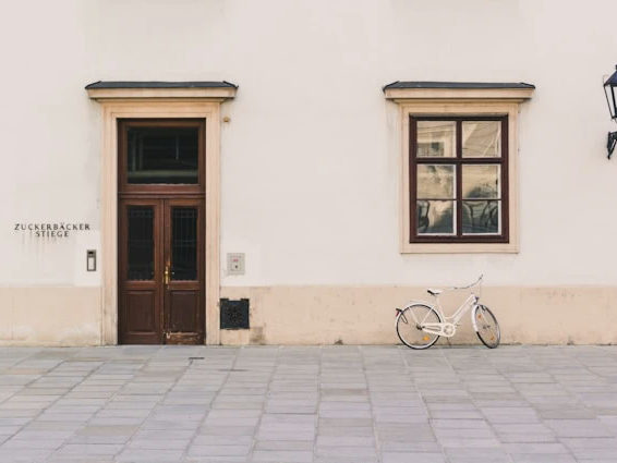 Facade photo with a bicycle, a wall lamp and painted text